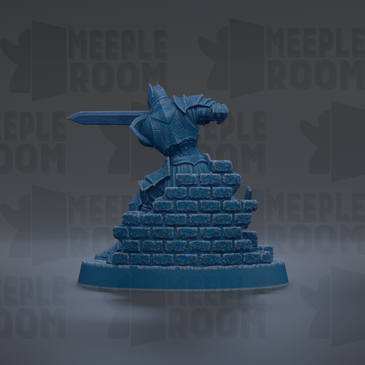 A blue figurine of a knight in armor, holding a sword, standing atop a pile of bricks.