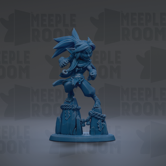 A blue figurine of a character with a large head and long hair, standing on a rock formation.