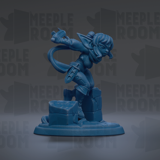 A blue figurine of a female character with a sword and shield, standing on a rock formation.