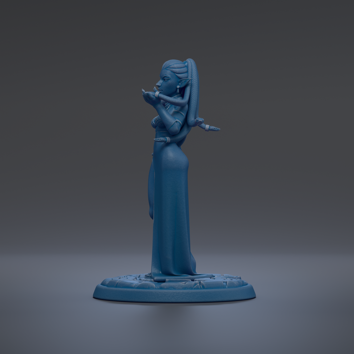 A blue figurine of a woman with a long dress and a long hairpiece stands on a blue base against a dark background.