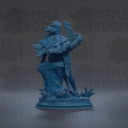 A blue statue of a figure holding a musical instrument, standing on a rock formation with plants and flowers around it.