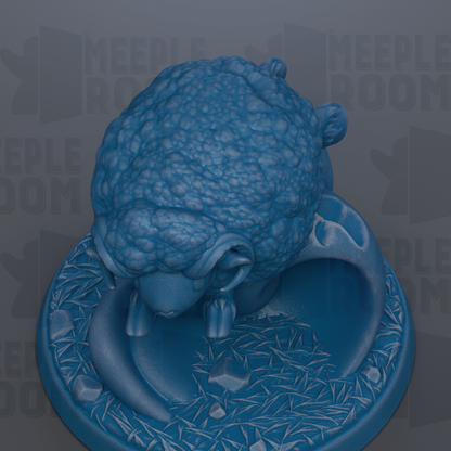 A blue, textured sheep figurine is displayed on a blue base with a patterned design.