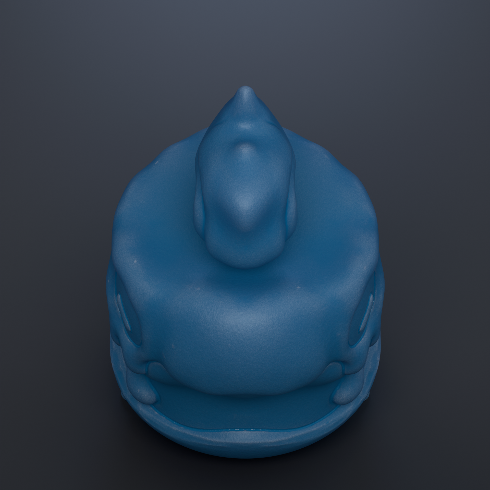 A blue, round object resembling a toy or figurine is shown against a dark background.