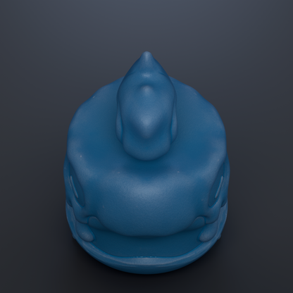 A blue, round object resembling a toy or figurine is shown against a dark background.