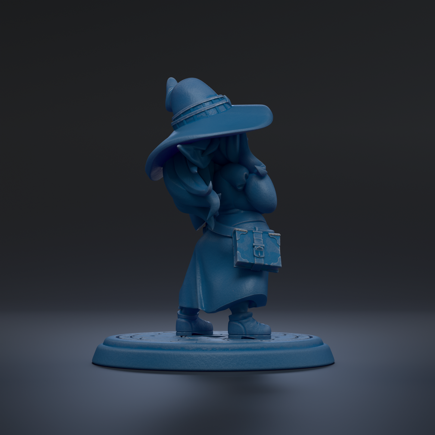 A blue figurine of a person wearing a hat and holding a book stands on a circular base against a dark background.