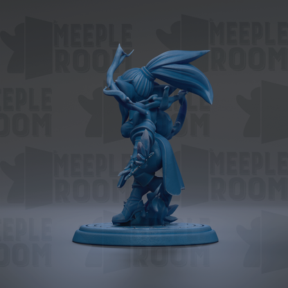 A blue figurine of a character with a large head and long hair, standing on a platform.