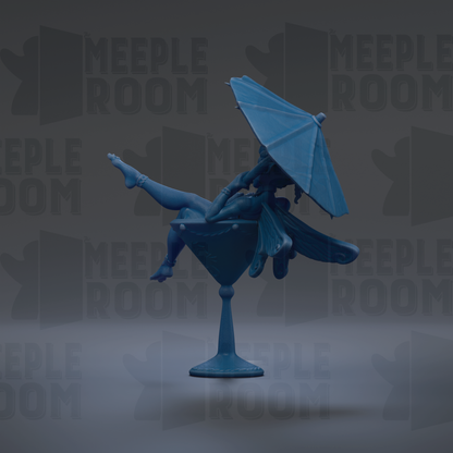 A blue figurine of a fairy sitting in a martini glass, holding an umbrella.