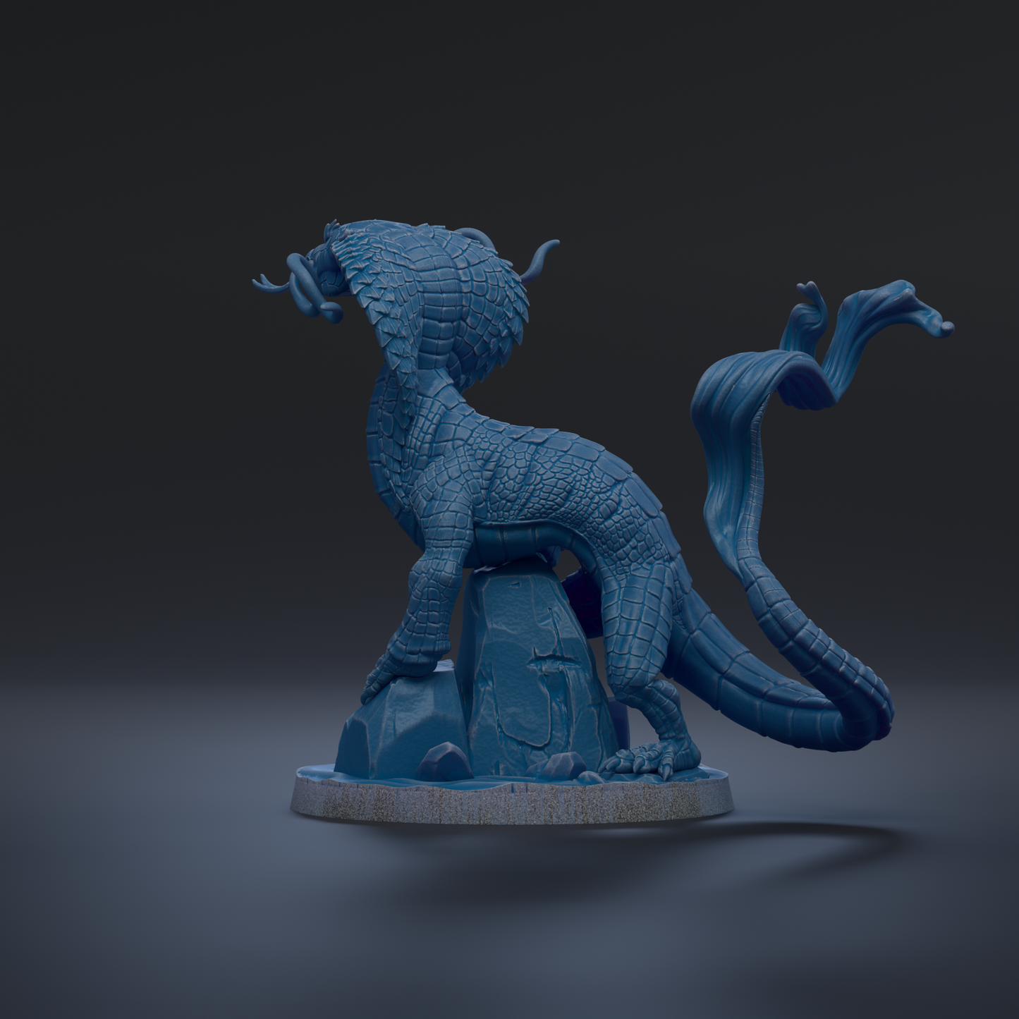 A 3D rendering of a blue dragon-like creature with a long, flowing tail and a fierce expression, standing on a rock formation against a dark background.