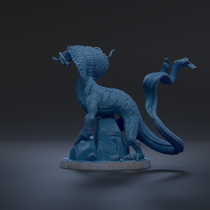 A 3D rendering of a blue dragon-like creature with a long, flowing tail and a fierce expression, standing on a rock formation against a dark background.