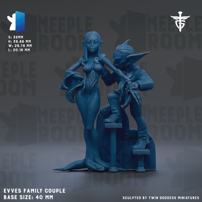 a blue figurine of a woman and a man, both depicted as fantasy characters, with the woman standing and the man sitting. The figurine is described as a "MEEPLE ROOM" and "EVVES FAMILY COUPLE" based on its size and base. The image is a "SQUILTED BY TWIN GODESS MINIATURES" piece, and it is described as a "MEEPLE ROOM" based on the repeated text throughout the image.