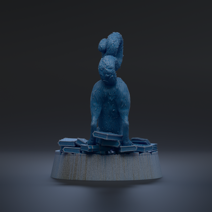 A blue, furry sculpture of a cat sitting on a pile of blue and white blocks, with a dark background.