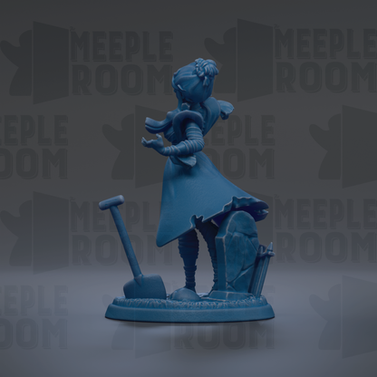 A blue figurine of a person standing on a base, with a shovel and a gravestone in the background.