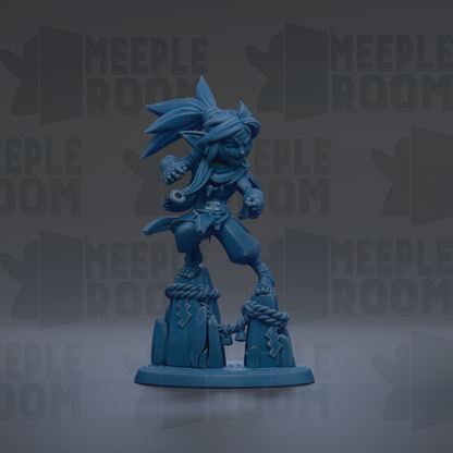 A blue figurine of a character with a large head and long hair, standing on a rock formation.