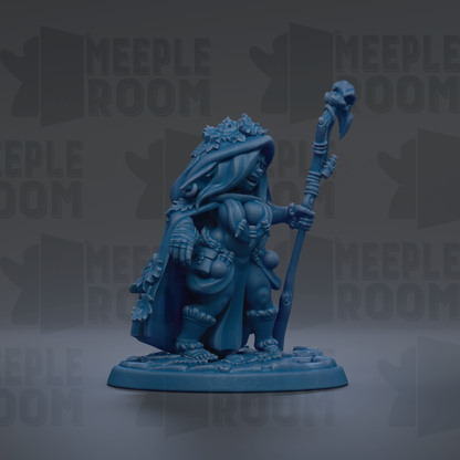 A blue figurine of a person holding a staff and wearing a hooded cloak, standing on a base.