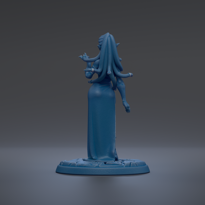 A blue figurine of a woman with long hair and a flowing dress stands on a base against a dark background.