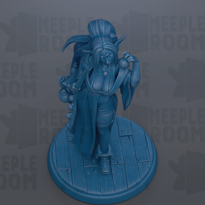 A blue figurine of a woman with a long, flowing robe and a headdress, standing on a wooden base.