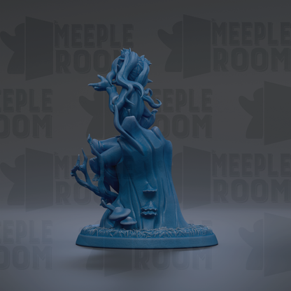 A blue figurine of a fantastical creature with long, flowing hair and a large head, sitting on a base with mushrooms and plants.