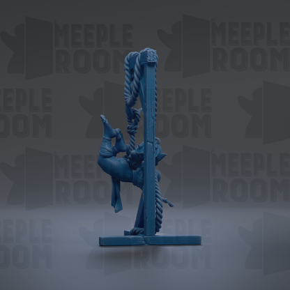 A blue figurine is hanging from a rope against a dark background with repeated text.