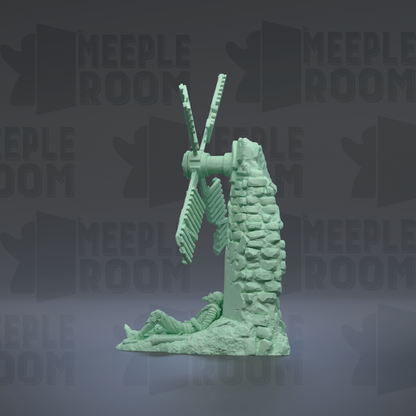 a green statue of a person sitting on a rock, with a windmill-like structure on top of it.