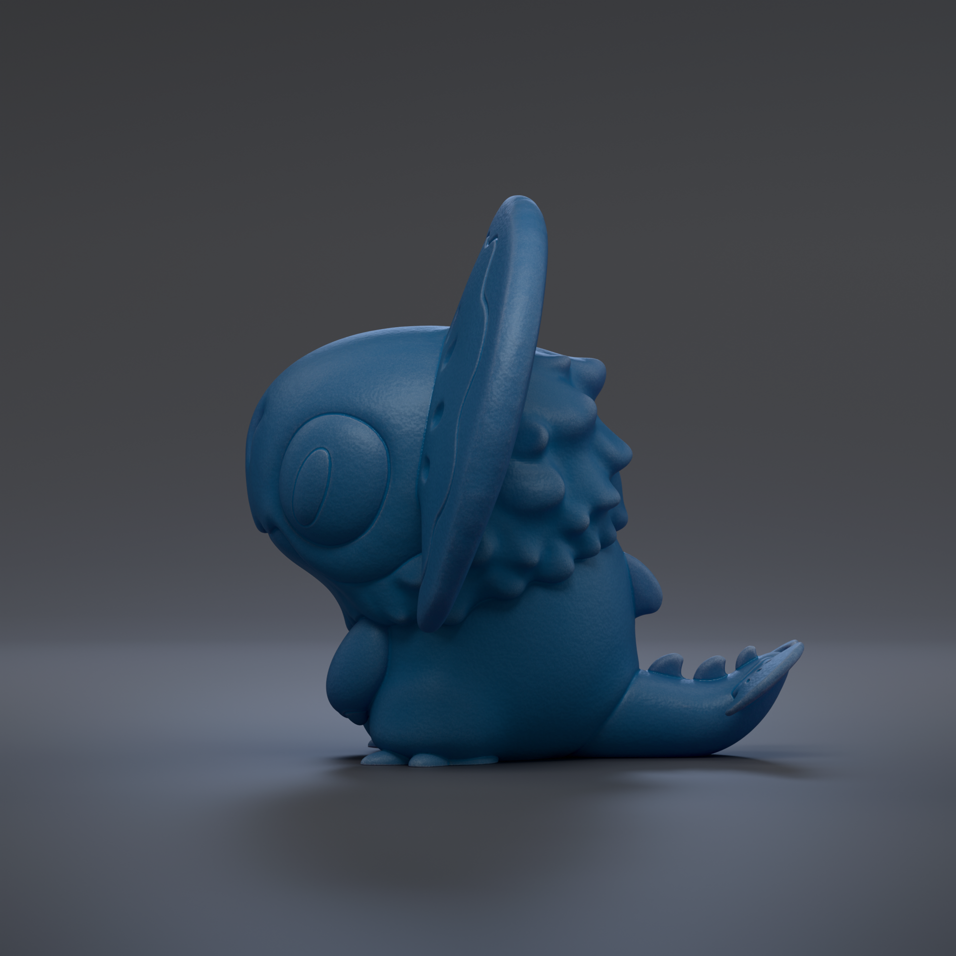 A blue, cartoon-like creature with a large head and small body is sitting on a gray surface.