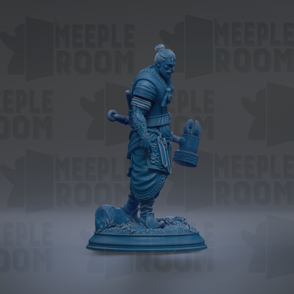 A blue statue of a warrior figure holding a shield and sword, standing on a base with a rock formation.