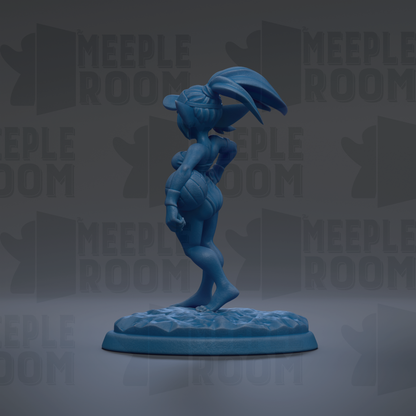 A blue figurine of a female character with a large head and long hair, standing on a base and facing away from the camera.