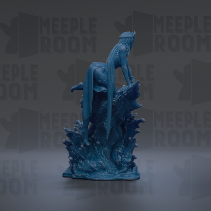 A blue figurine of a woman with long hair and a crown, sitting on a rock formation, is the main focus of the image.