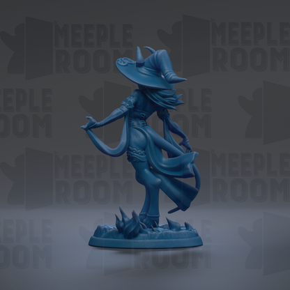 A blue figurine of a witch with a flowing dress and a large hat, standing on a base with a dark background.