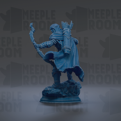 A blue statue of a figure holding a staff and wearing a cape, standing on a rock.