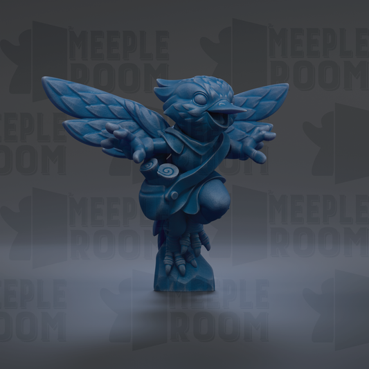 A blue bird statue with wings spread, standing on a rock.