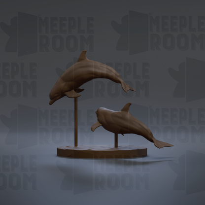 two bronze sculptures of dolphins leaping out of the water, displayed on a circular base.