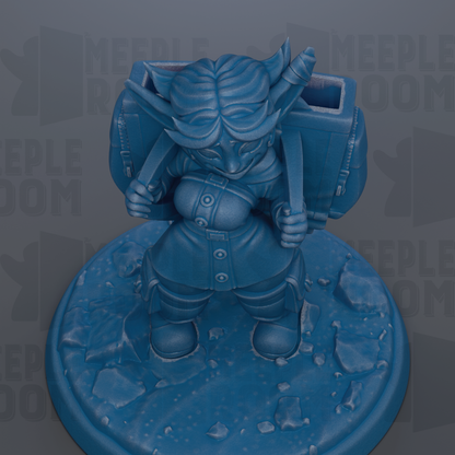 A blue figurine of a person with horns and a backpack, standing on a rocky surface.