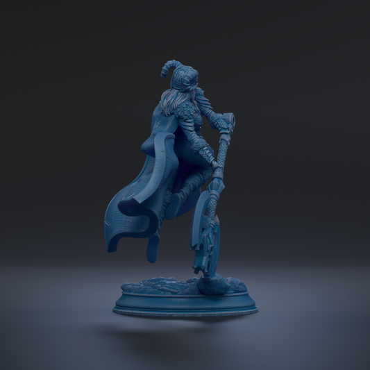 A 3D rendering of a female character with a flowing cape and holding a weapon, standing on a base.