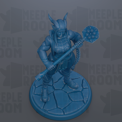 A blue figurine of a warrior-like character holding a weapon and standing on a rocky base.