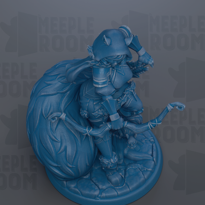 A blue figurine of a character with horns and a flowing cape, standing on a rock formation.