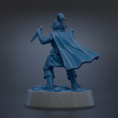 A blue figurine of a person with a cape and a sword, standing on a pedestal.