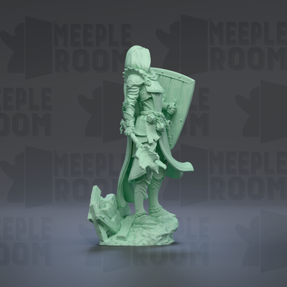 A green statue of a knight standing on a rock, holding a shield and sword.