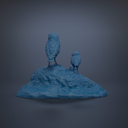 Two blue bird statues perched on a rocky outcrop against a dark background.