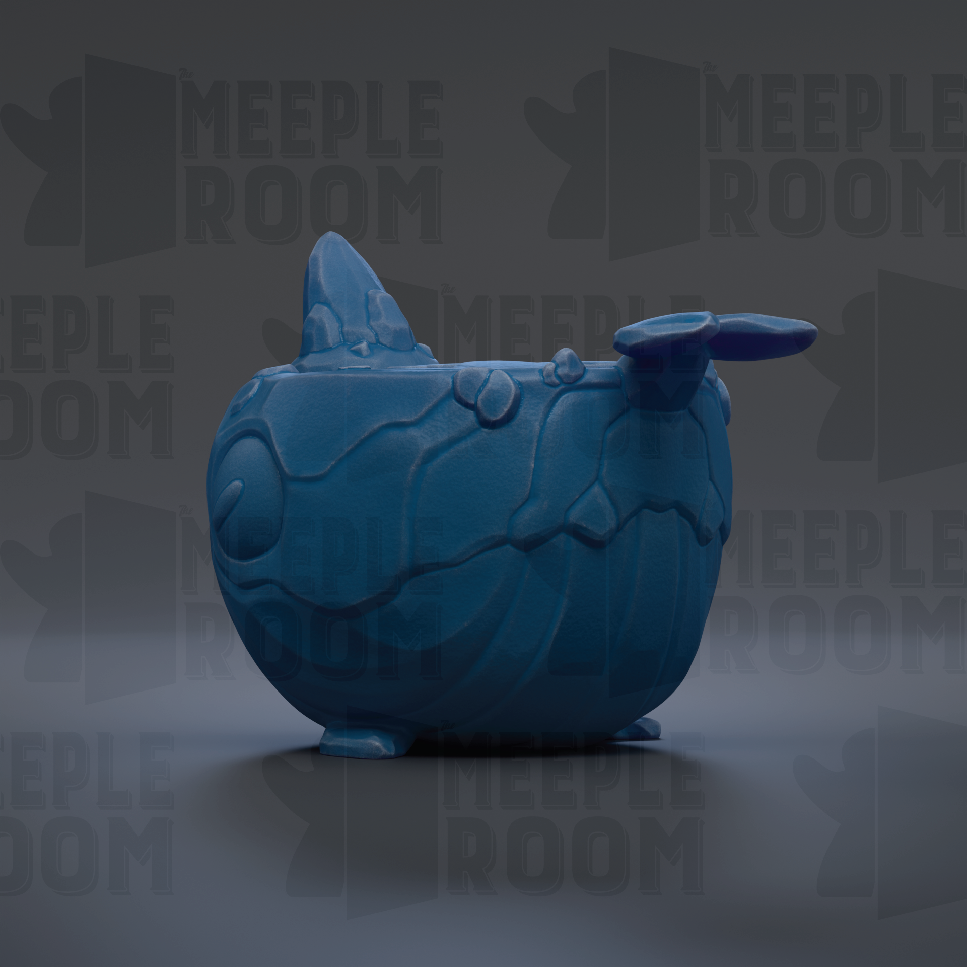 A blue ceramic object resembling a whale or sea creature, with a textured surface and a pointed fin-like structure on top.