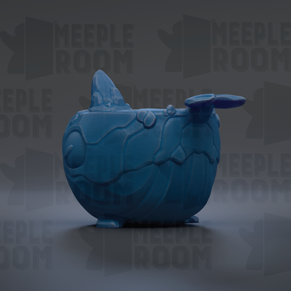 A blue ceramic object resembling a whale or sea creature, with a textured surface and a pointed fin-like structure on top.