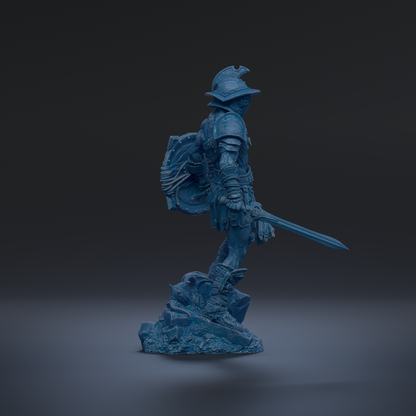A blue statue of a warrior standing on a rock, holding a sword and shield.