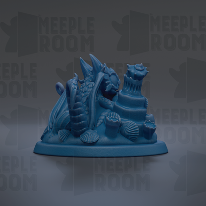 A blue ceramic figurine depicting a sea creature, possibly a dragon or sea monster, surrounded by various sea-themed objects such as shells and coral.