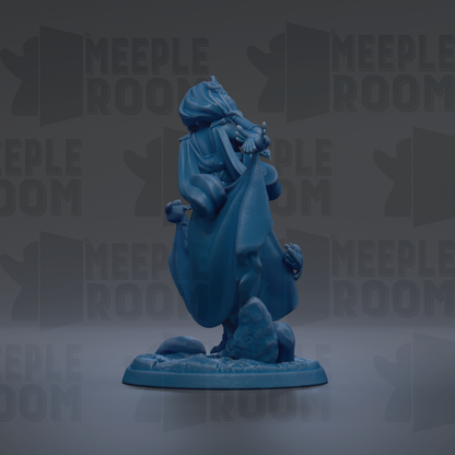 A blue figurine of a person standing on a rock, with a flowing robe and holding a staff.