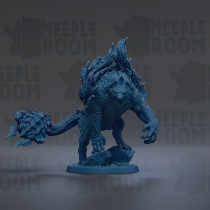 A blue, three-dimensional figurine of a fantastical creature with sharp teeth and claws, standing on a rock formation.