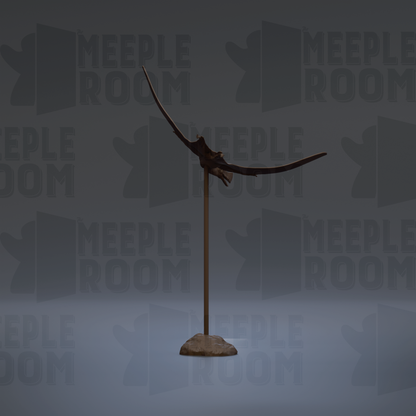 A dark-colored metal sculpture of a bird-like creature stands on a rock against a gray background with repeated "MEPLE ROOM" text.