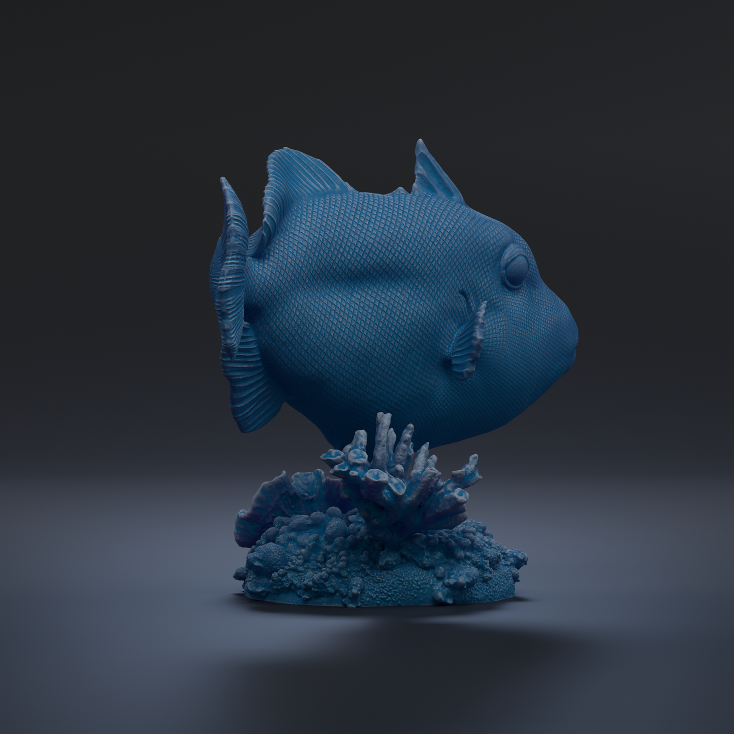 A blue fish sculpture is displayed on a coral base against a dark background.