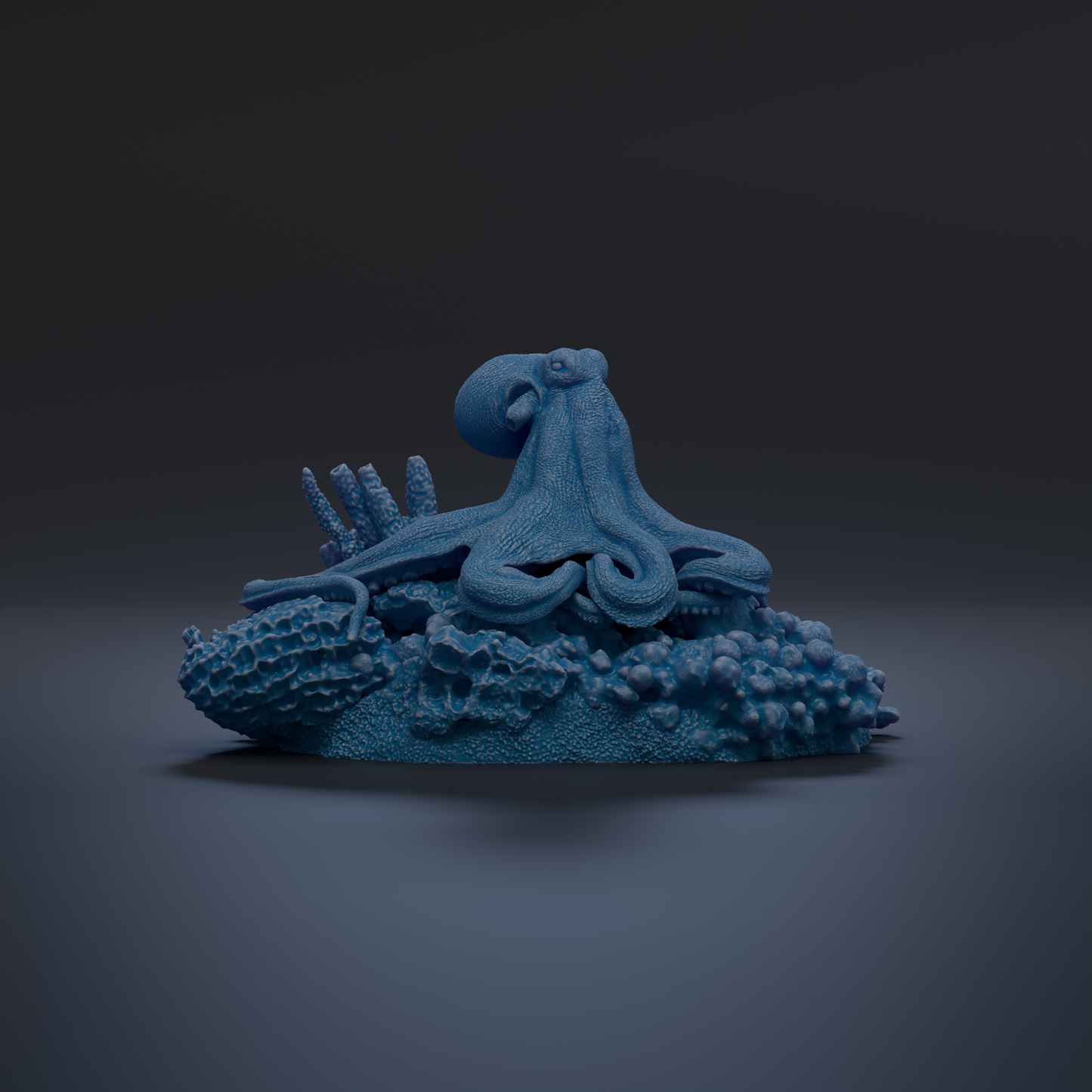 A blue octopus sculpture is displayed on a dark surface, surrounded by various marine life elements.