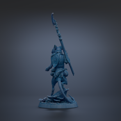 A blue figurine of a warrior standing on a rock, holding a spear and shield.