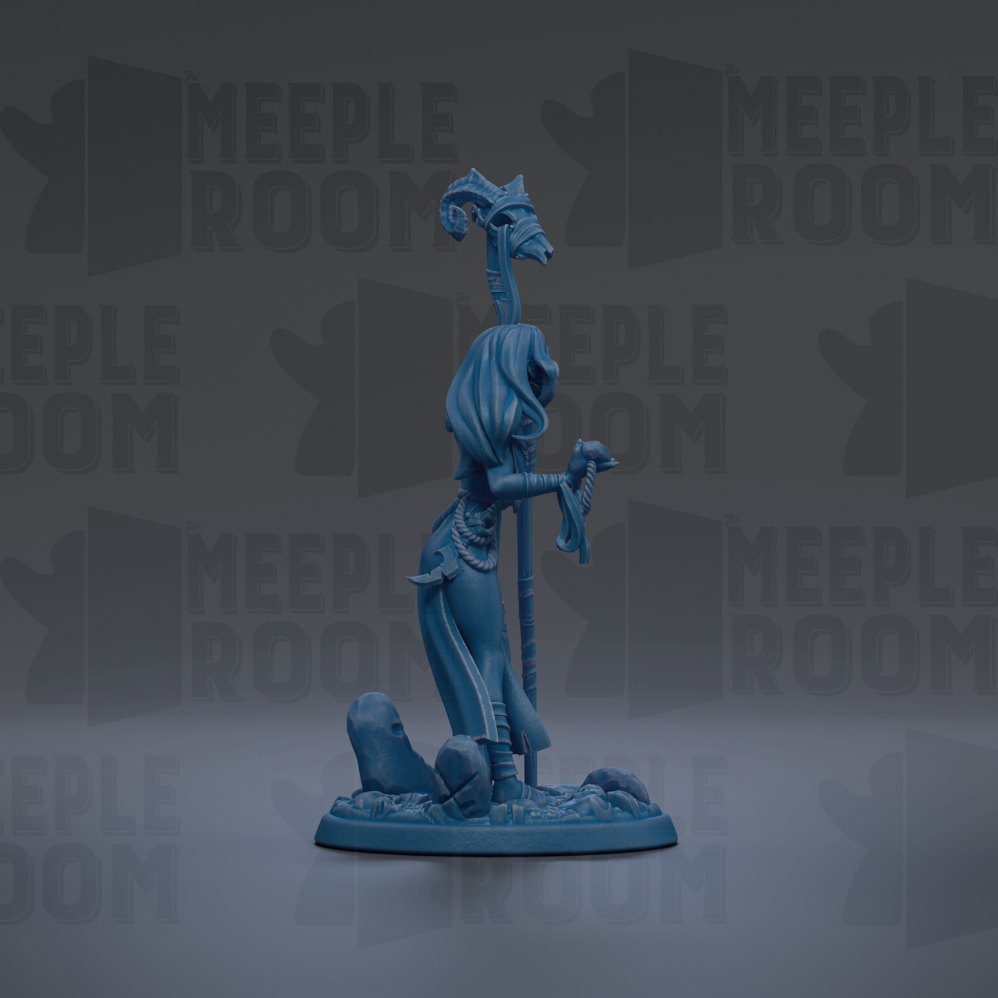 A blue figurine of a woman with a staff and a hat, standing on a rock formation.