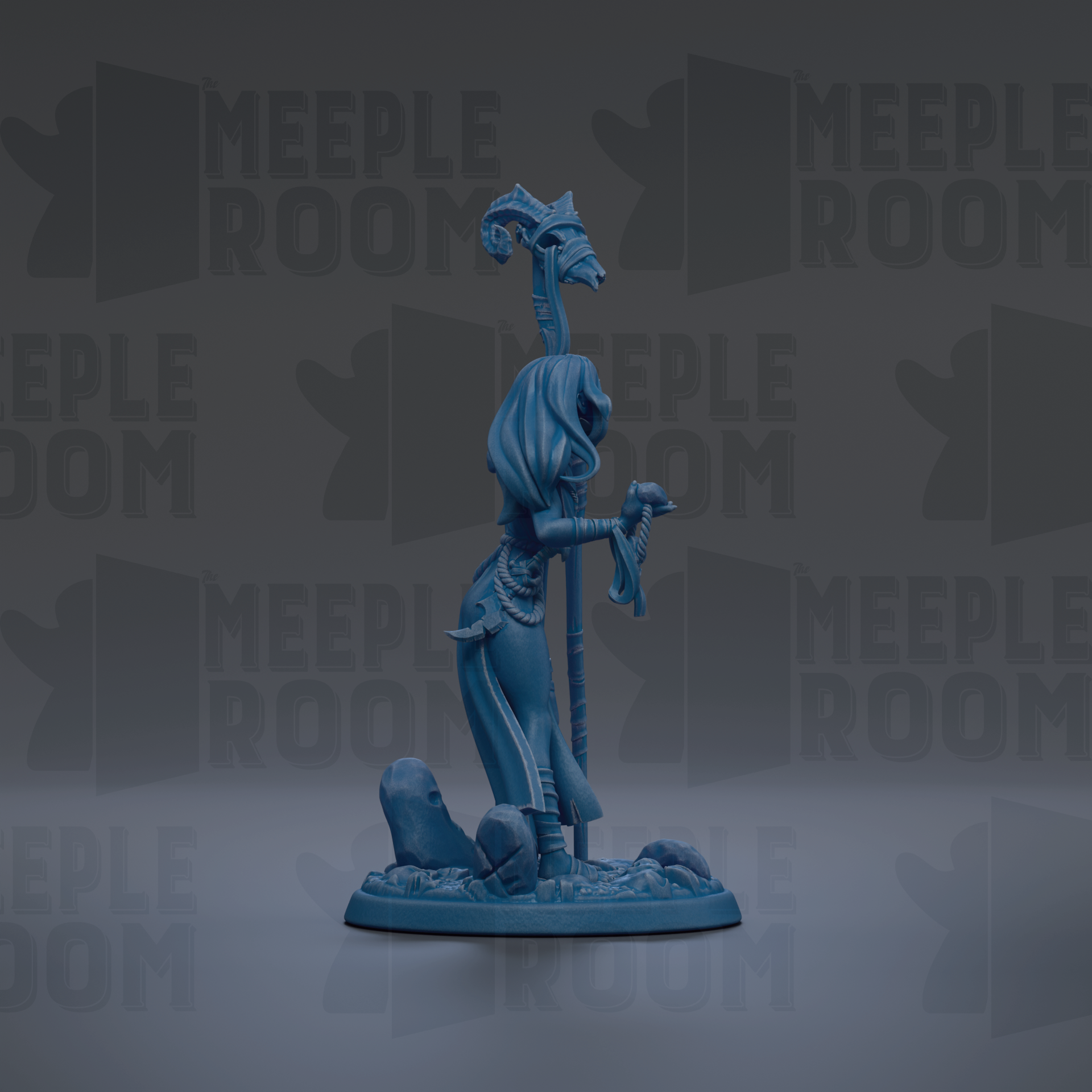 A blue figurine of a woman with a staff and a hat, standing on a rock formation.